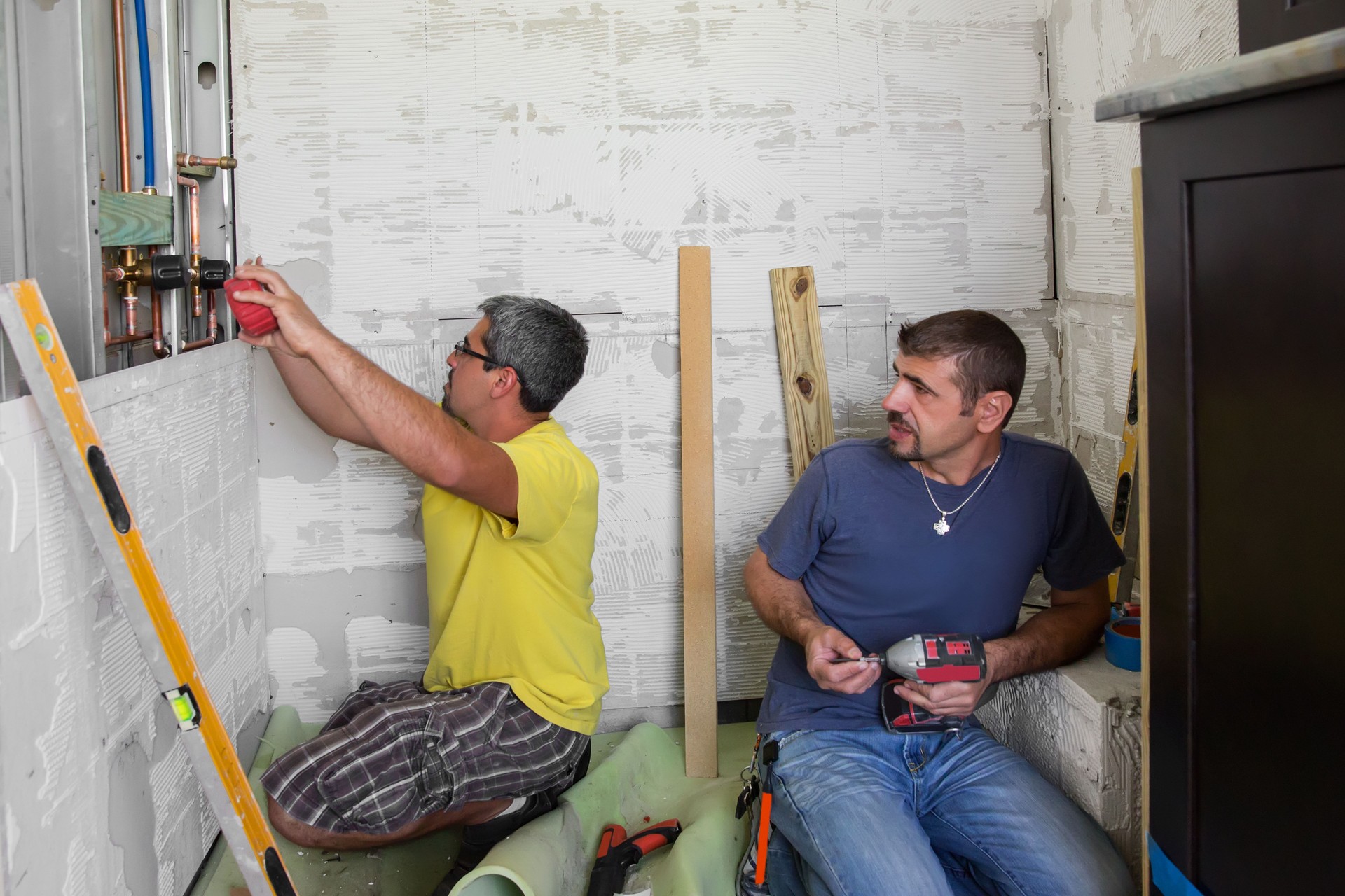 Workers construct a bathroom shower