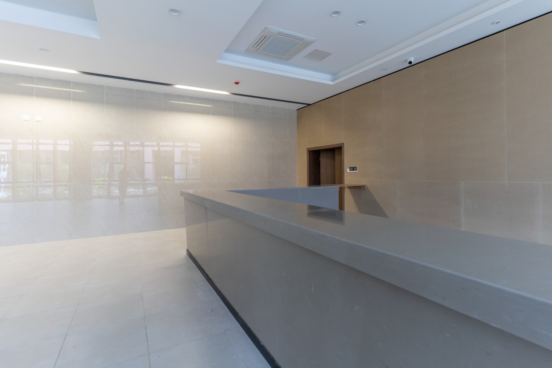 An empty lobby reception area with tiled floors and walls