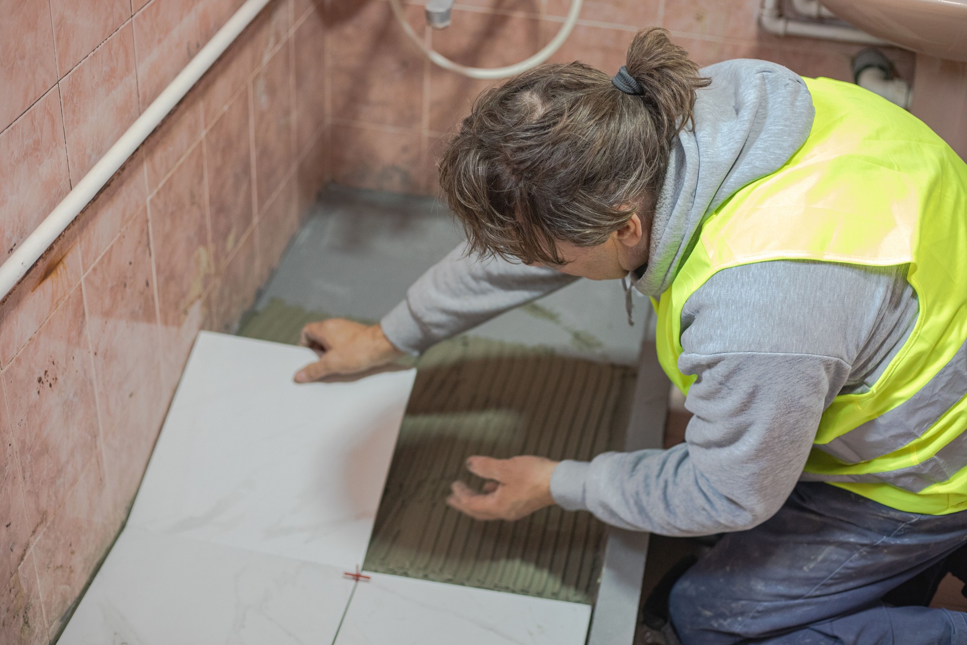 Construction worker installing ceramic tiles